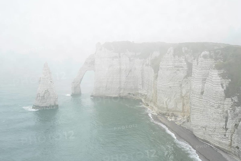 L'Aiguille and the Porte D'Aval, a natural arch in the chalk cliffs at Etretat in the mist, Côte d'Albâtre, Upper Normandy, France, Europe