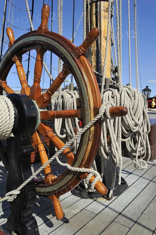 Steering wheel and ropes coiled around belaying pins aboard the Grand Turk, Etoile du Roy, a three-masted sixth-rate frigate replica of HMS Blandford, built in 1741 and based in Saint Malo, Brittany, France, Europe