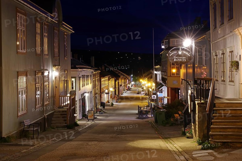 A quiet city street at night with illuminated buildings and a street sign, pedestrian zone, Unesco World Heritage Site, mining town, Röros, Norway, Europe