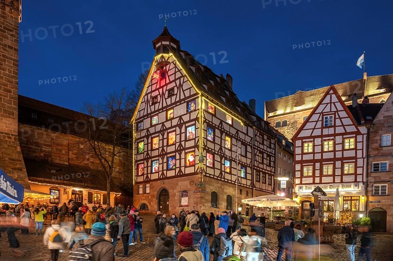 Historic Pilkatushaus with an Advent calendar on 18 December 2024 at dusk, behind the Imperial Castle, Tiergärtnertorplatz, Nuremberg, Middle Franconia, Bavaria, Germany, Europe