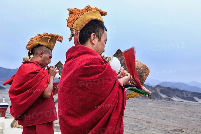THIKSEY, INDIA, SEPTEMBER 4, 2011: Two Tibetan Buddhist monks blowing conches during morning pooja, Thiksey gompa, Ladakh, India, Asia