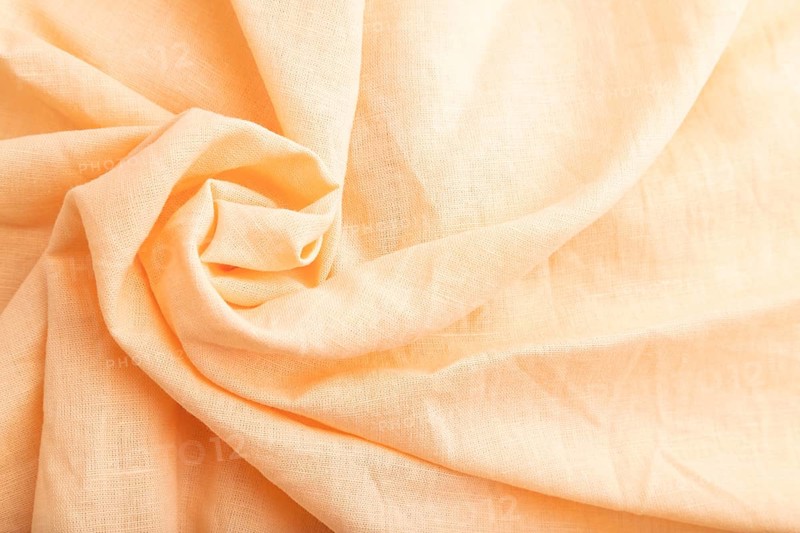 Fragment of orange linen tissue. Top view, flat lay, natural textile background and texture. wave concept, abstract, spiral form