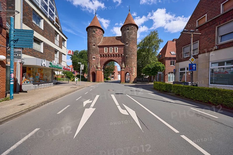 Historic city gate Lüdinghauser Tor against blue sky with cumulus clouds and Lüdinghauser Strasse in Dülmen, Münsterland, Coesfeld district, North Rhine-Westphalia, Germany, Europe