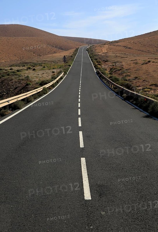 Tarmac road crossing barren desert mountainous land between Pajara and La Pared, Fuerteventura, Canary Islands, Spain, Europe