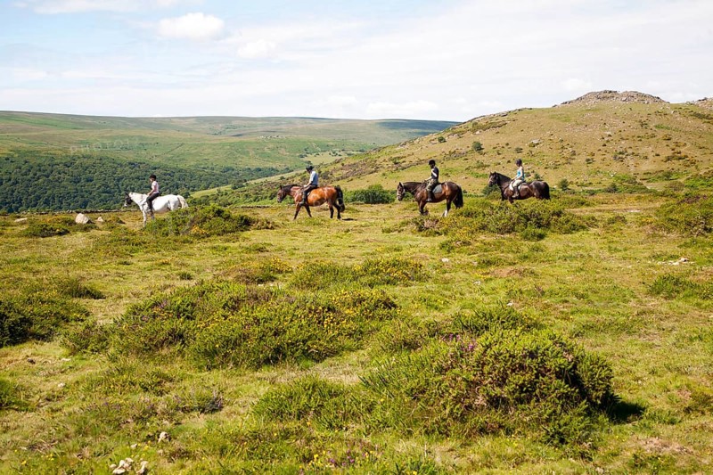 People riding horses by Sharp Tor, Dartmoor national park, Devon, England, UK