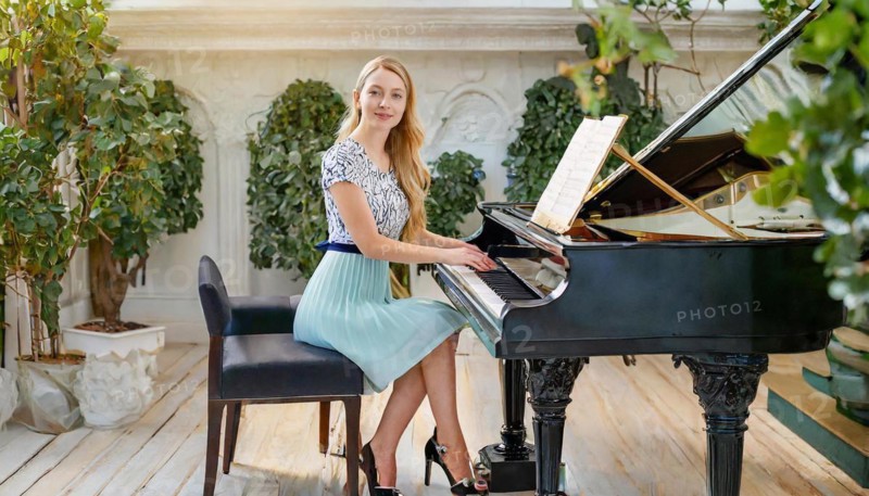 A pianist in a light-coloured dress plays music on a grand piano in an elegantly decorated room with plants, AI generated, AI generated