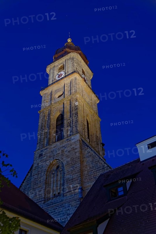 The evening sky is illuminated by the striking church tower of St Martin's Basilica, Amberg, Upper Palatinate, Bavaria, Germany, Europe
