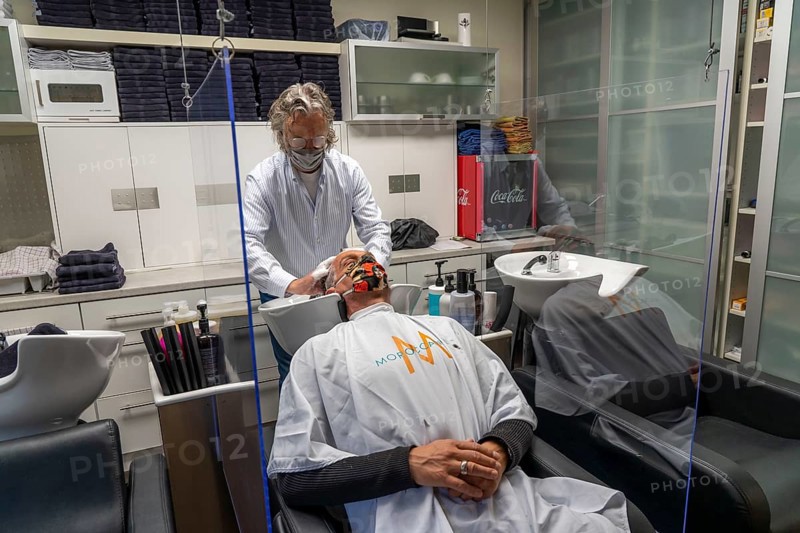 Hairdressing salon in Essen-Rüttenscheid, first customer after 6 weeks, shop closed due to Corona, hairdresser and customer with mouth-nose protection, breathing mask, Plexiglas protective walls, spit protection, when washing hair, distance regulation, Essen, North Rhine-Westphalia, Germany, Europe