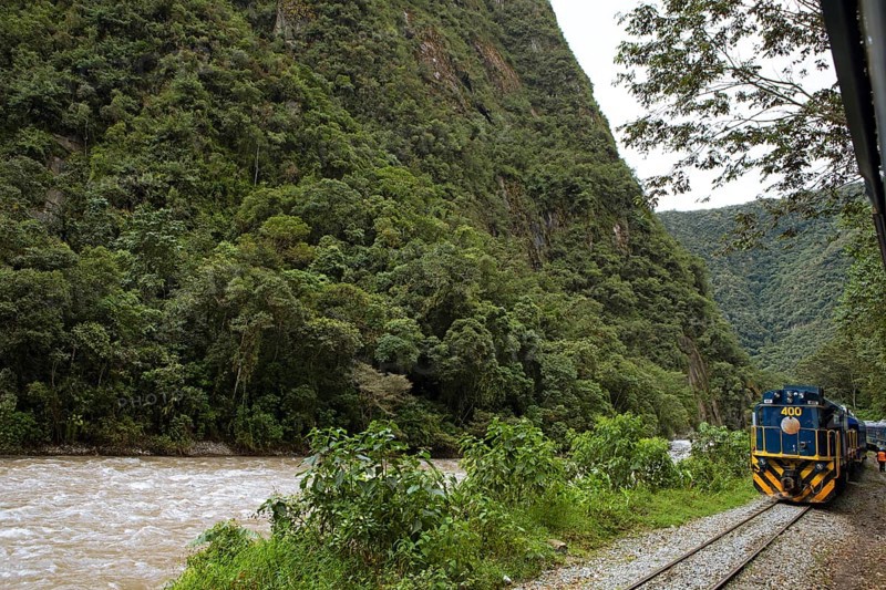 Perurail train travelling through the Andes from Ollantaytambo to Mach Picchu, in front the river Rio Urubamba, Cusco region, Peru, South America