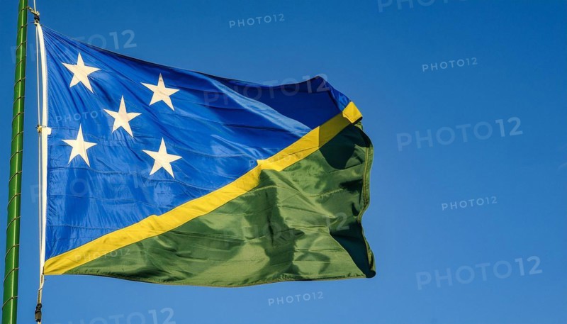 The flag of Solomon Islands, Solomon Islands, island nation in the South Seas, flutters in the wind, isolated against a blue sky, Oceania