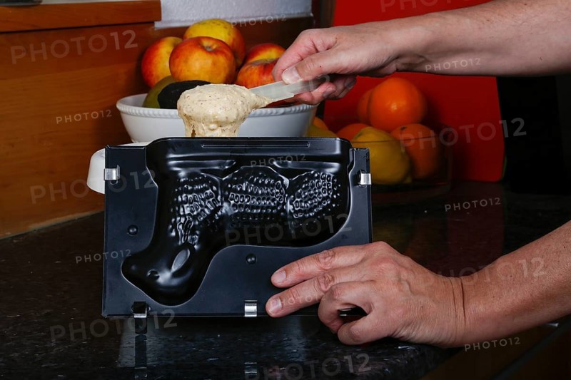 Swabian cuisine, baking, preparation of Easter lamb, filling raw dough into baking tin, sweet sponge, Easter pastry, cake, typical Swabian, traditional cuisine, food photography, men's hands, studio, Germany, Europe