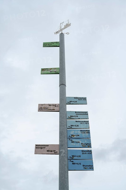 Mast showing the storm surge heights of past centuries, harbour, Greetsiel, East Frisia, Lower Saxony, Germany, Europe