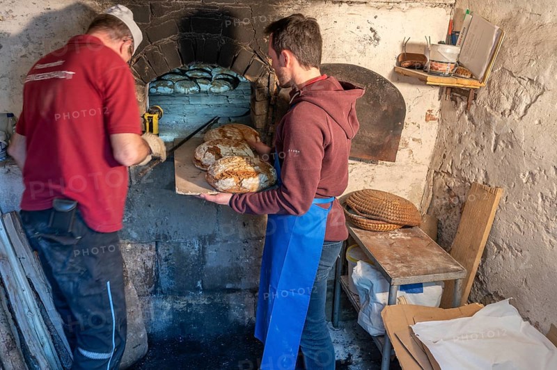 Freshly baked wood-fired bread is taken out of the wood-fired oven, baking oven festival in Franconia, Bavaria, Germany, Europe