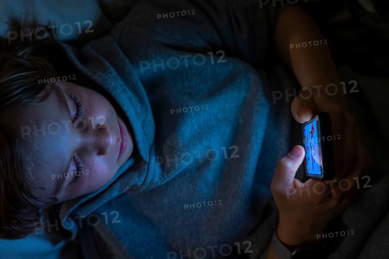A boy plays computer games on a mobile phone, smartphone