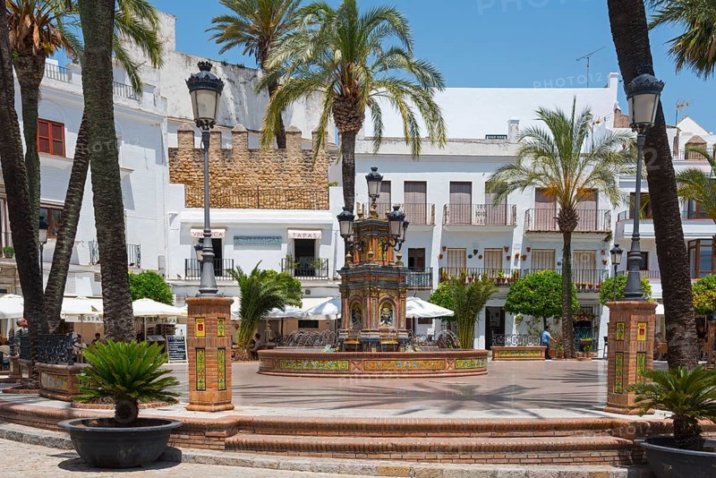 Lively market square with decorative fountain surrounded by palm trees and white buildings, fountain with azulejos, Plaza de España, square, old town centre, Vejer de la Frontera, Cadiz province, Cadiz, Andalusia, Spain, Europe