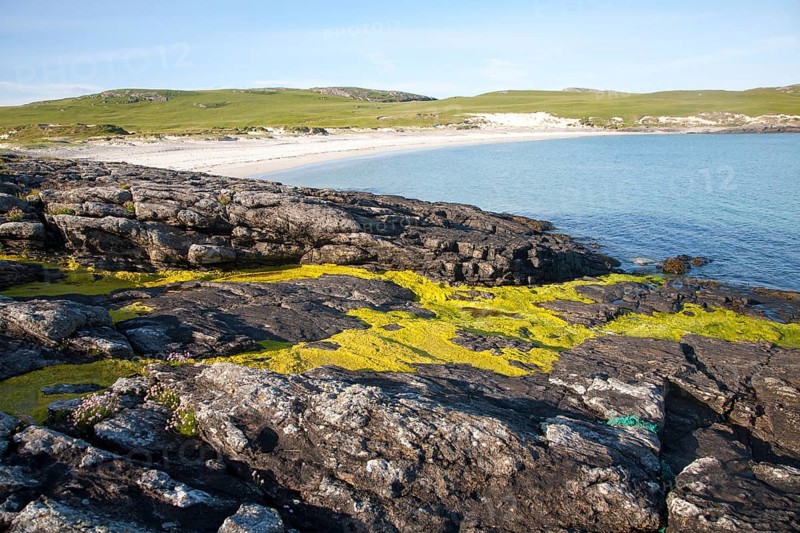 Rocky headland and sandy beach at Bagh a Deas, South Bay, Vatersay island, Barra, Outer Hebrides, Scotland, UK