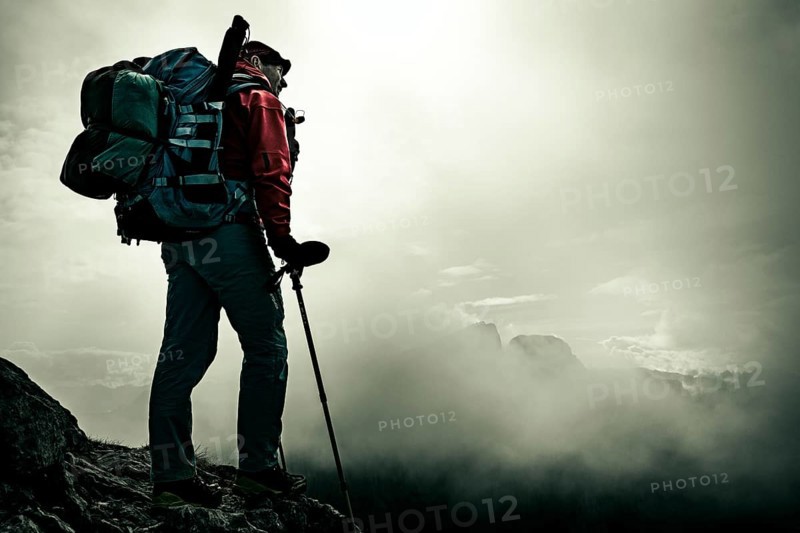 Mountaineer with luggage in the background Rätikon mountains with cloudy sky, Tschagguns, Rätikon, Montafon, Vorarlberg, Austria, Europe