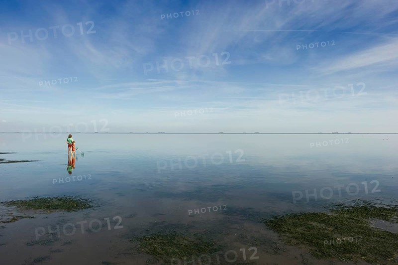 Woman with child walking through the mudflats, Wyk, Föhr, North Frisia, Schleswig-Holstein, Germany, Europe