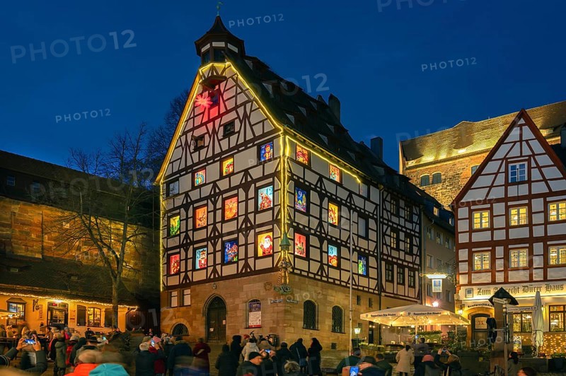 Pilatushaus, built in 1489, a historic town house with an Advent calendar on 18 December 2024 at dusk, the Imperial Castle on the right, Tiergärtnertorplatz, Nuremberg, Central Franconia, Bavaria, Germany, Europe