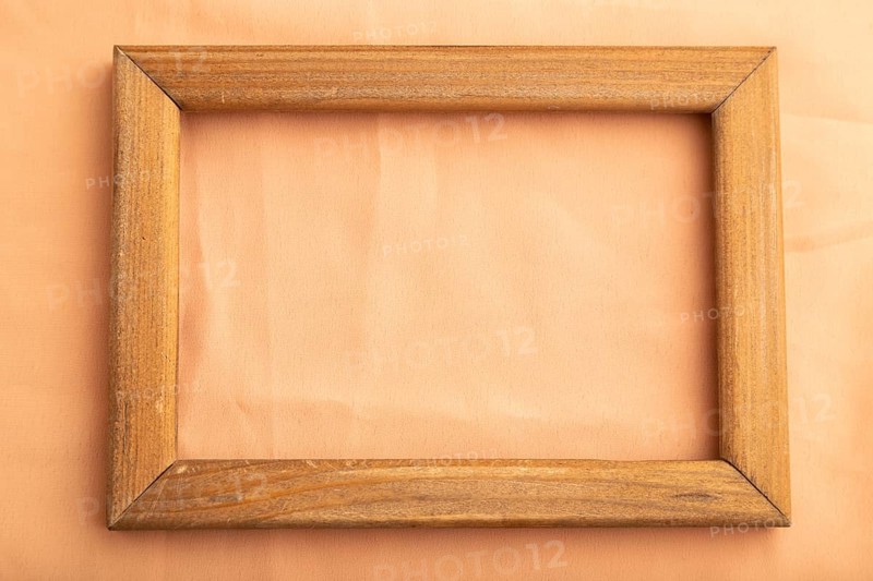 Wooden frame on smooth orange linen tissue. Top view, flat lay, natural textile background and texture