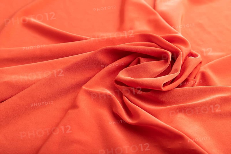 Fragment of red linen tissue. Side view, natural textile background and texture. wave concept, abstract, spiral form