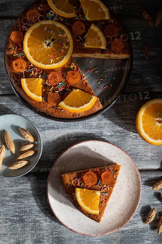 Orange cake on a gray wooden background. Hard light. contrast, low key. Top view, flat lay, close up