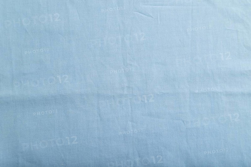 Fragment of smooth cotton blue tissue. Top view, flat lay, natural textile background and texture
