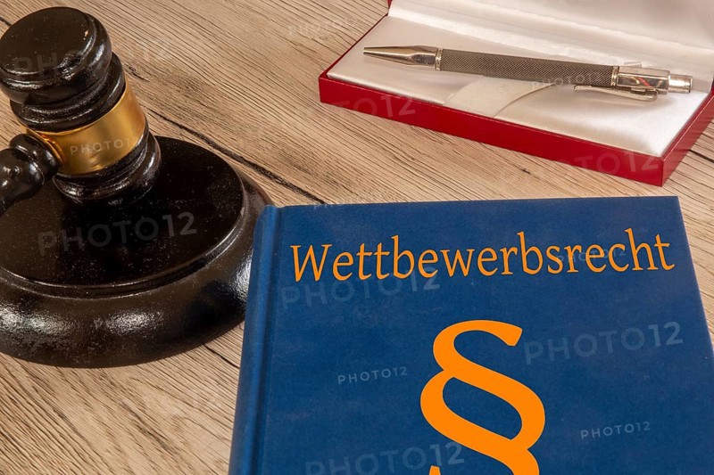 Symbolic image: Competition law textbook next to a judge's gavel