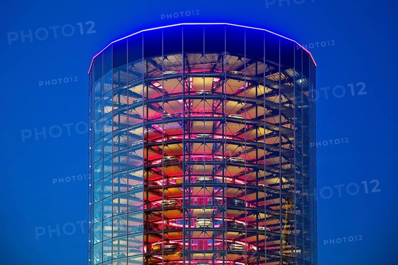 An illuminated car tower with new cars for delivery in the evening, Autostadt, Volkswagen AG, Wolfsburg, Lower Saxony, Germany, Europe