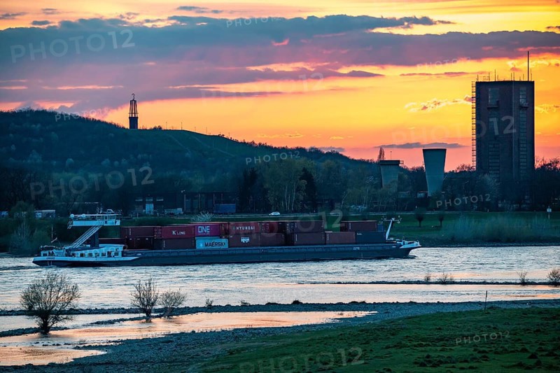 Cargo ship on the Rhine near Duisburg-Beeckerwerth, Rheinpreussen spoil tip in Mörs, spoil tip sign Das Geleucht, winding tower of the former Rheinpreußen Schacht VIII colliery, Duisburg, North Rhine-Westphalia, Germany, Europe