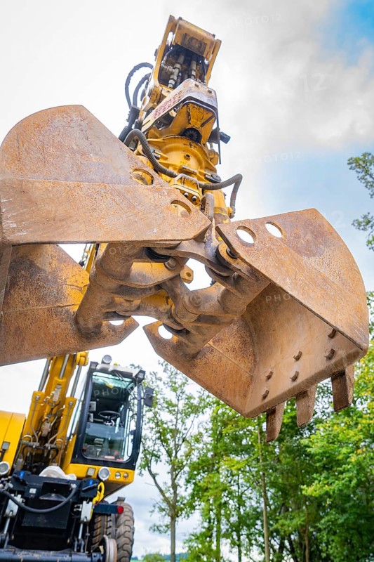 Shovel of an excavator on a construction site under a cloudy sky, track construction, Hermann Hessebahn, Calw, Black Forest, Germany, Europe