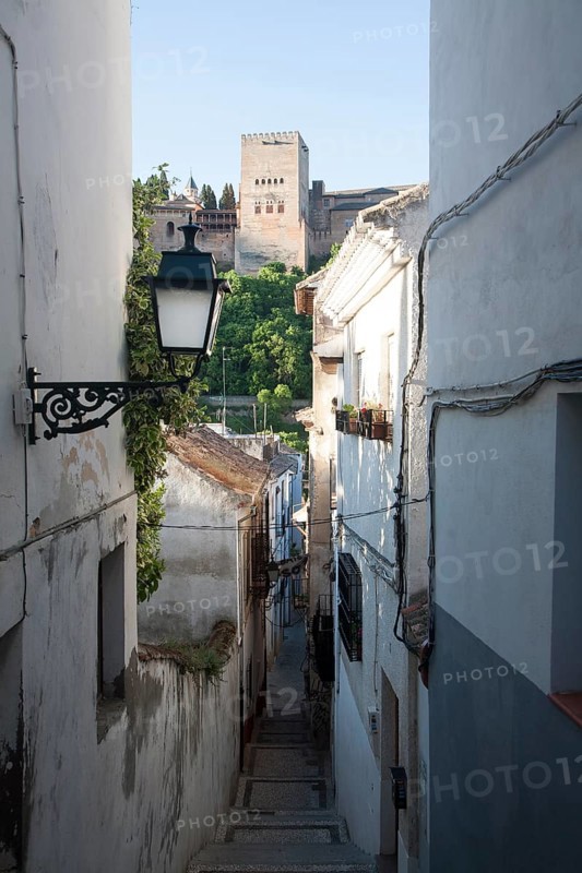 Narrow alleyway named Candil in the Moorish housing district of Albaicin, Granada, Spain with a view to the Alhambra