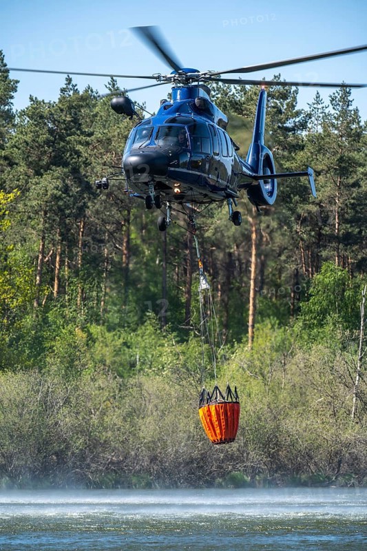 Forest fire in the German-Dutch border region near Niederkrüchten-Elmpt, in a nature reserve, deployment of fire-fighting helicopters, Eurocopter EC 155, Federal Police with extinguishing water tank, Bambi Bucket