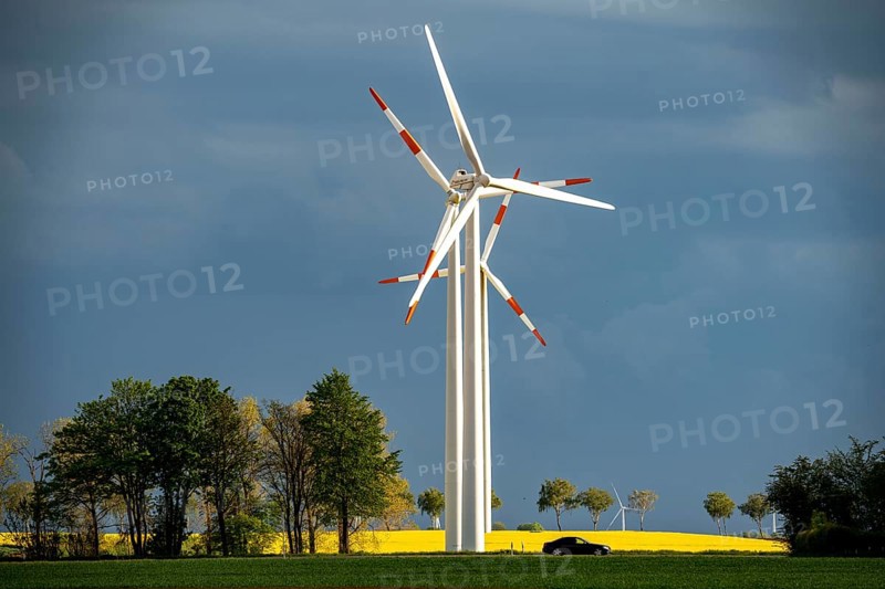 Wind turbines on a rape field, dark rain clouds, in the Rhenish lignite mining area, country road, near Erkelenz-Holzweiler