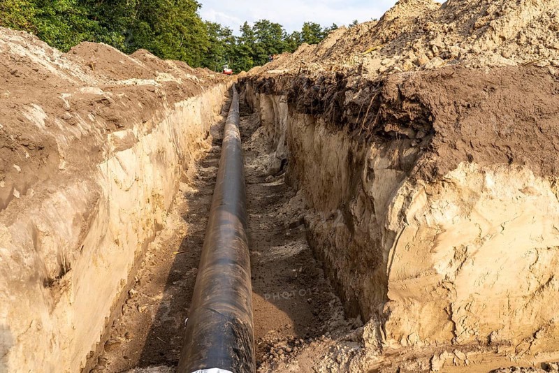 Laying of district heating pipes, next to a field, with maize, the district heating comes from a biogas plant and is fed directly into households in the neighbourhood, private provider, near Delbrück, North Rhine-Westphalia, Germany, Europe