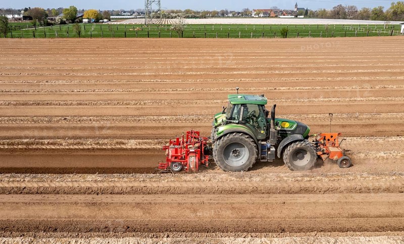 A farmer builds asparagus ridges on a field with the help of an asparagus tiller, in which the asparagus then grows, Dormagen, North Rhine-Westphalia, Germany, Europe