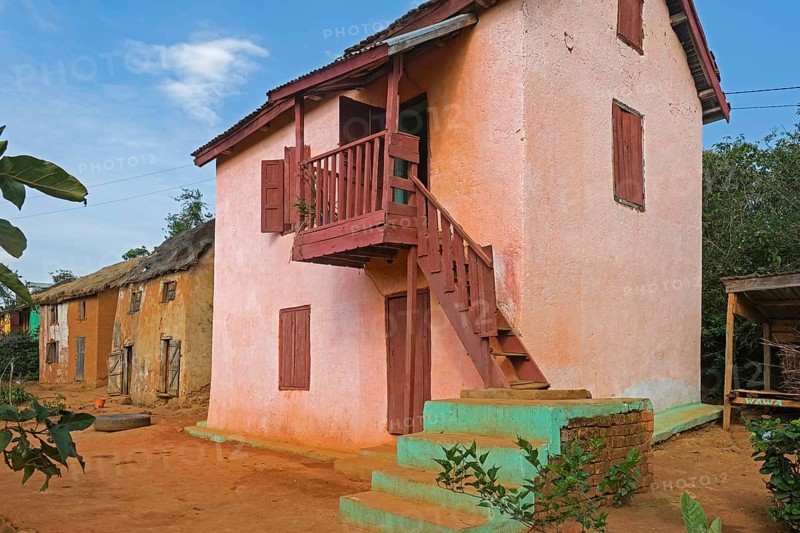 Traditional Malagasy two-story houses in street of rural village in the Ambositra District, Amoron'i Mania Region, Central Madagascar