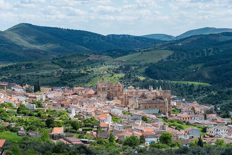 A historic town nestled in a hilly landscape on a clear day with clouds and blue sky, Guadalupe, Cáceres province, Caceres, Extremadura, Spain, Europe