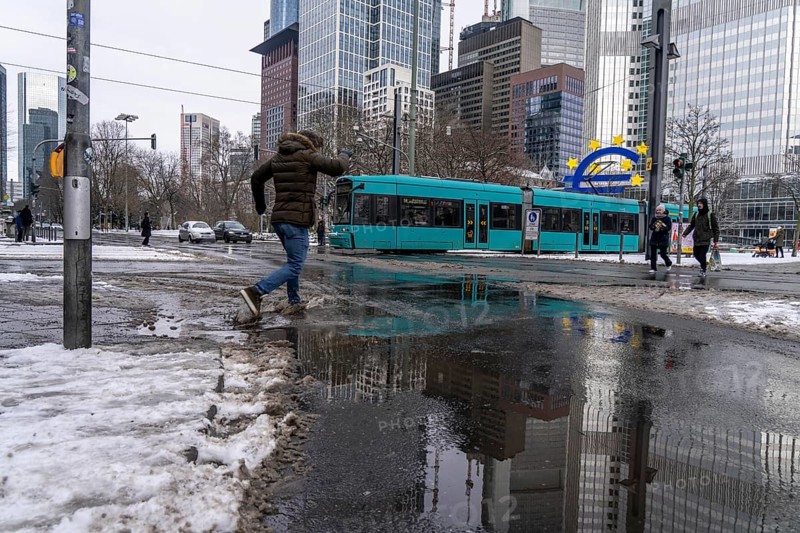 Winter in the city, Gallusanlage street, puddles, pools of water, melt water, pedestrians, Frankfurt, Hesse, Germany, Europe