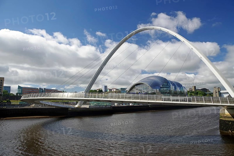 A modern bridge spans a river, behind which a futuristic glass building stands out, Milleniums Bridge, Newcastle, North England, Great Britain