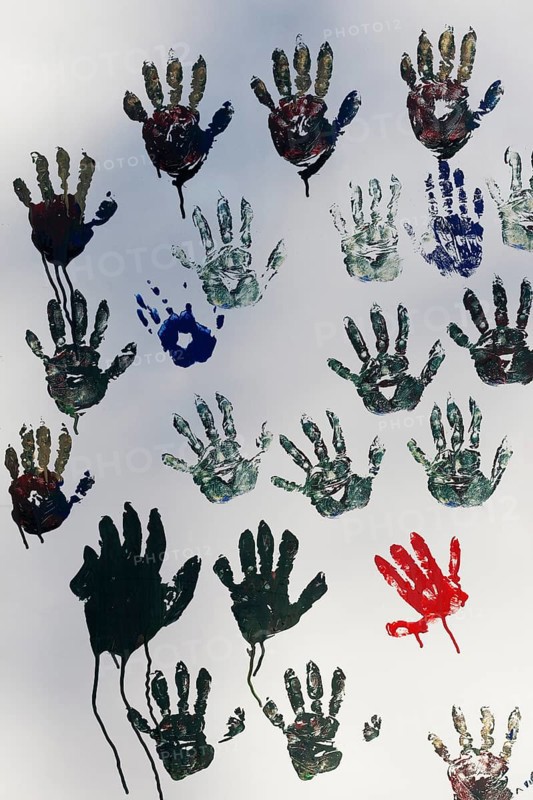 Handprints on a white wall, single red print between many grey ones, Duisburg, North Rhine-Westphalia, Germany, Europe