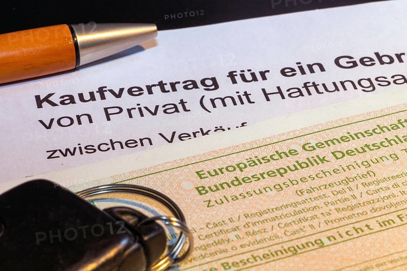 Symbolic image: Purchase contract for a car with vehicle registration document and car keys