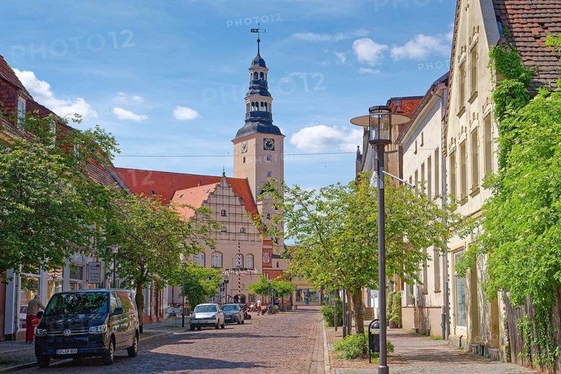 Residential and commercial buildings in Rudolf-Breitscheid-Straße, paved with cobblestones, in the old town centre of Gardelegen in the Altmark, with the town hall in the background. Hanseatic town of Gardelegen, Saxony-Anhalt, Germany, Europe