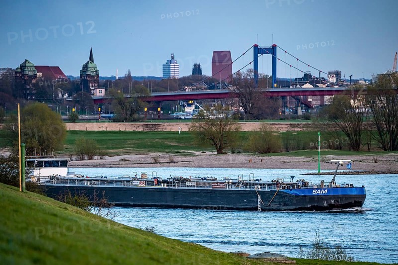 Cargo ship on the Rhine near Duisburg-Beeckerwerth, skyline of the city centre, with town hall, North Rhine-Westphalia State Archive Tower, Friedrich Ebert Bridge, Duisburg, North Rhine-Westphalia, Germany, Europe