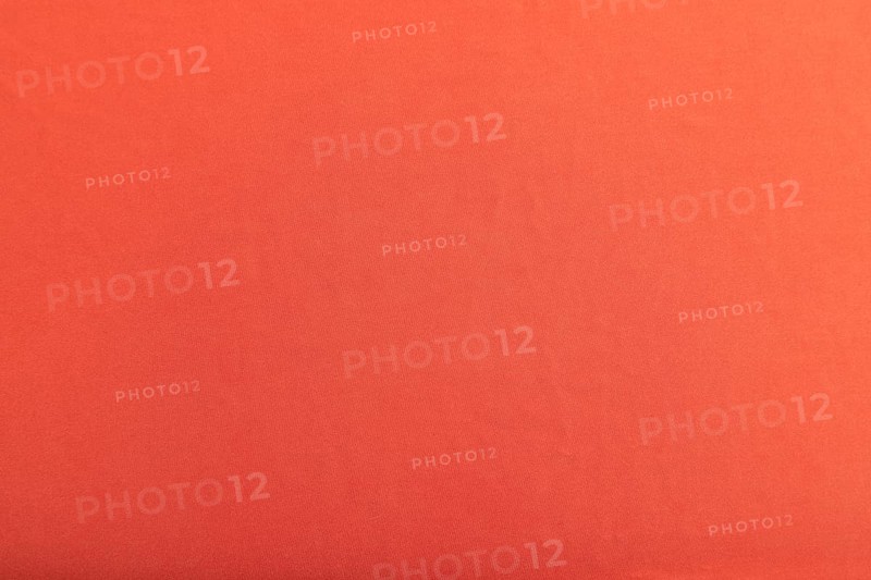 Fragment of smooth red silk tissue. Top view, flat lay, natural textile background and texture