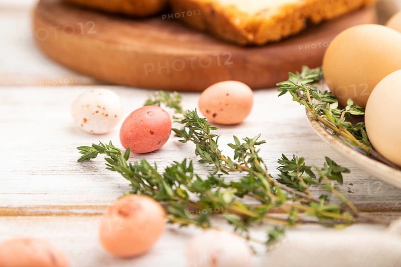 Homemade easter pie with raisins and eggs on plate on a white wooden background and linen textile. side view, close up, selective focus