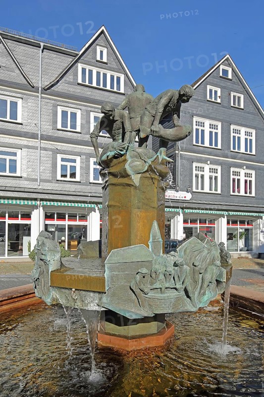 Fountain with sculptures on the history of the town, fishermen with salmon, fish figures, slate houses, old town fountain, Bad Laasphe, Rothaargebirge, North Rhine-Westphalia, Germany, Europe