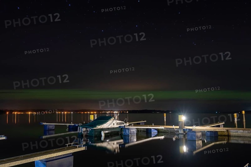 Northern lights (aurora borealis) shine on a starry night over Lake Plau, Ganzlin, Mecklenburg-Vorpommern, Germany, Europe
