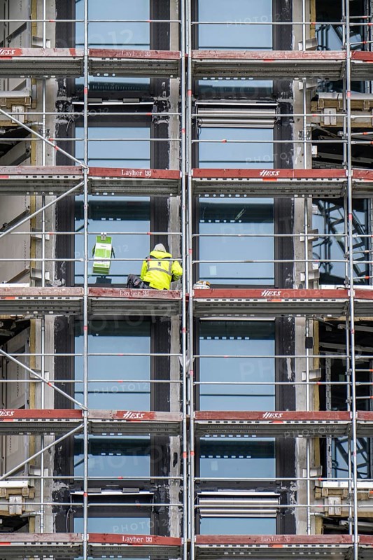 Large construction site, construction of a residential building with many flats, scaffolding, windows are installed, being sealed, grouted, Frankfurt am Main, Hesse, Germany, Europe