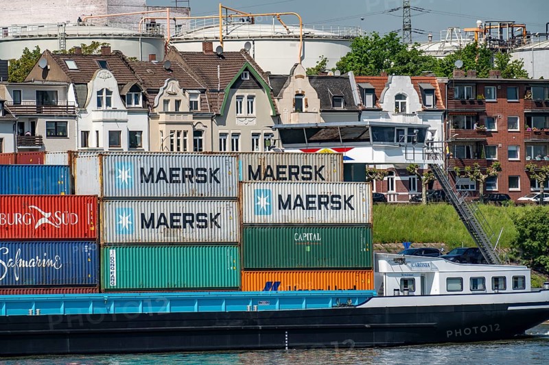 Residential buildings on Wilhelmallee, Rhine promenade, in Duisburg-Hombergg, on the Rhine, in front of the tanks and buildings of the Venator Deutschland chemical plant, formerly Sachtleben Chemie, cargo ship, Duisburg, North Rhine-Westphalia, Germany, Europe